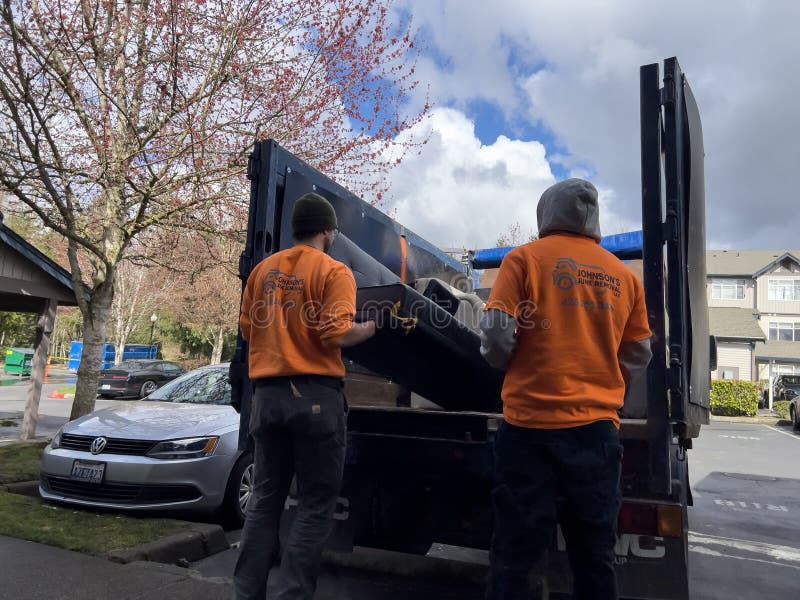 Team loading unwanted furniture onto a junk removal truck